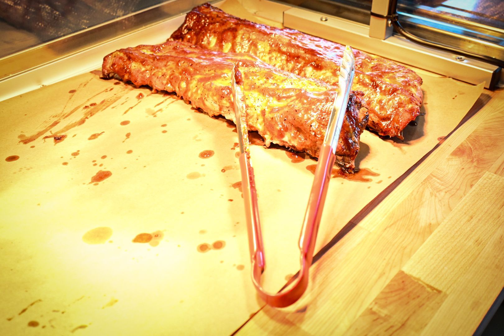 A pair of tongs holding a piece of meat on a table