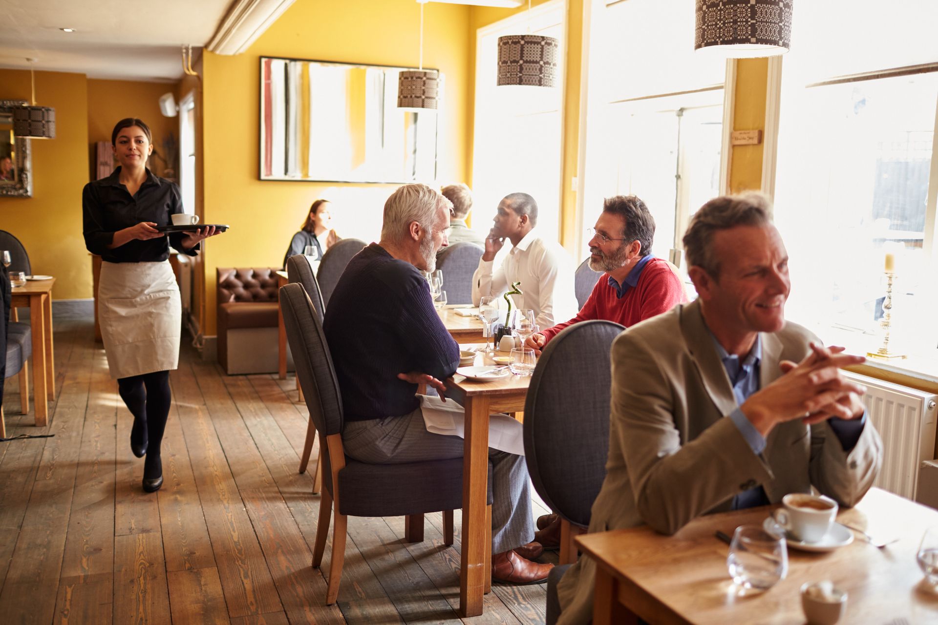 Group of diners enjoying their meal and socializing at a local restaurant.