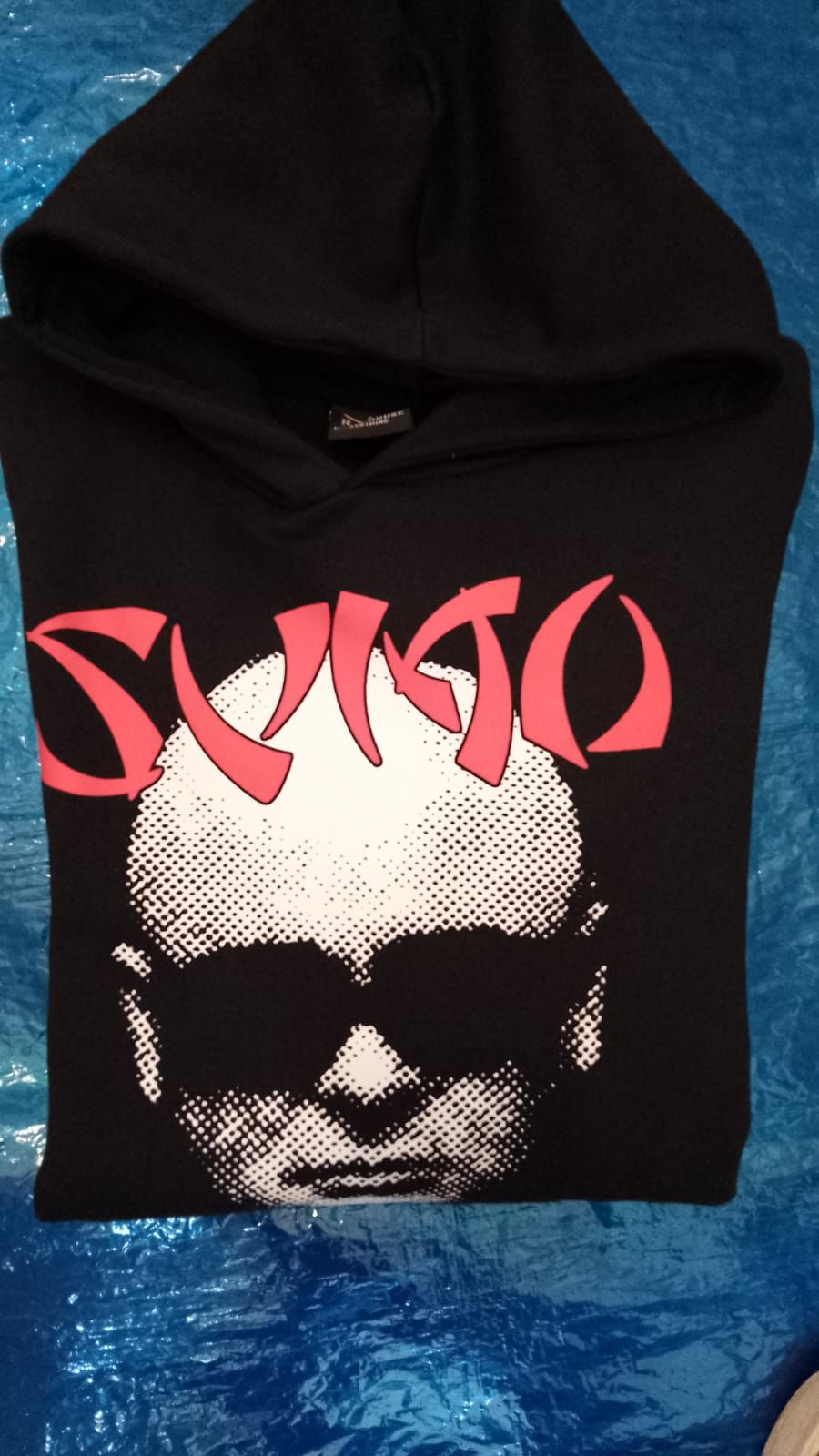Sudadera negra con capucha, estampado rojo y una calavera estilizada en la parte delantera.