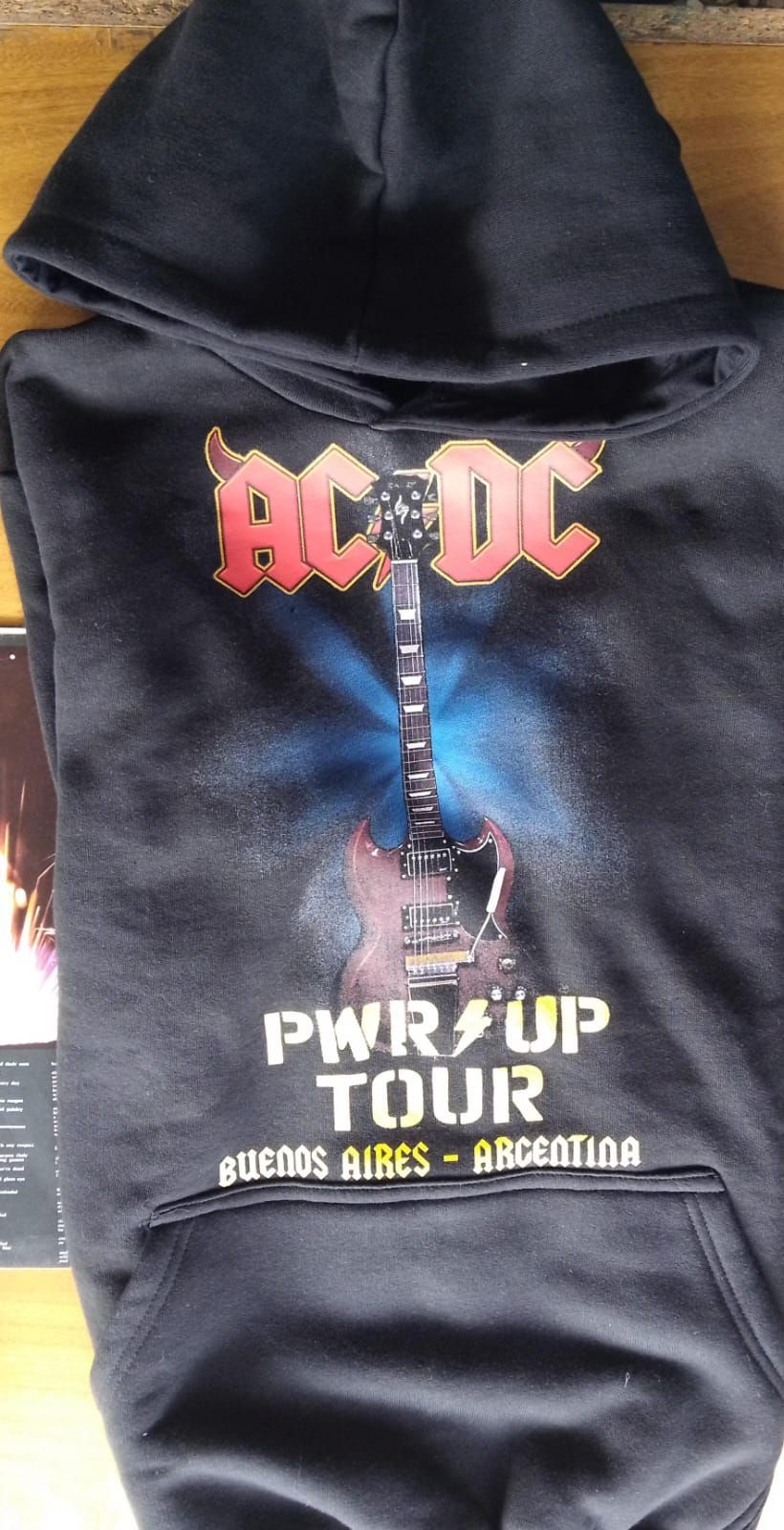 Sudadera negra con el logo de AC/DC y el texto “PWR/UP TOUR” en la parte delantera.