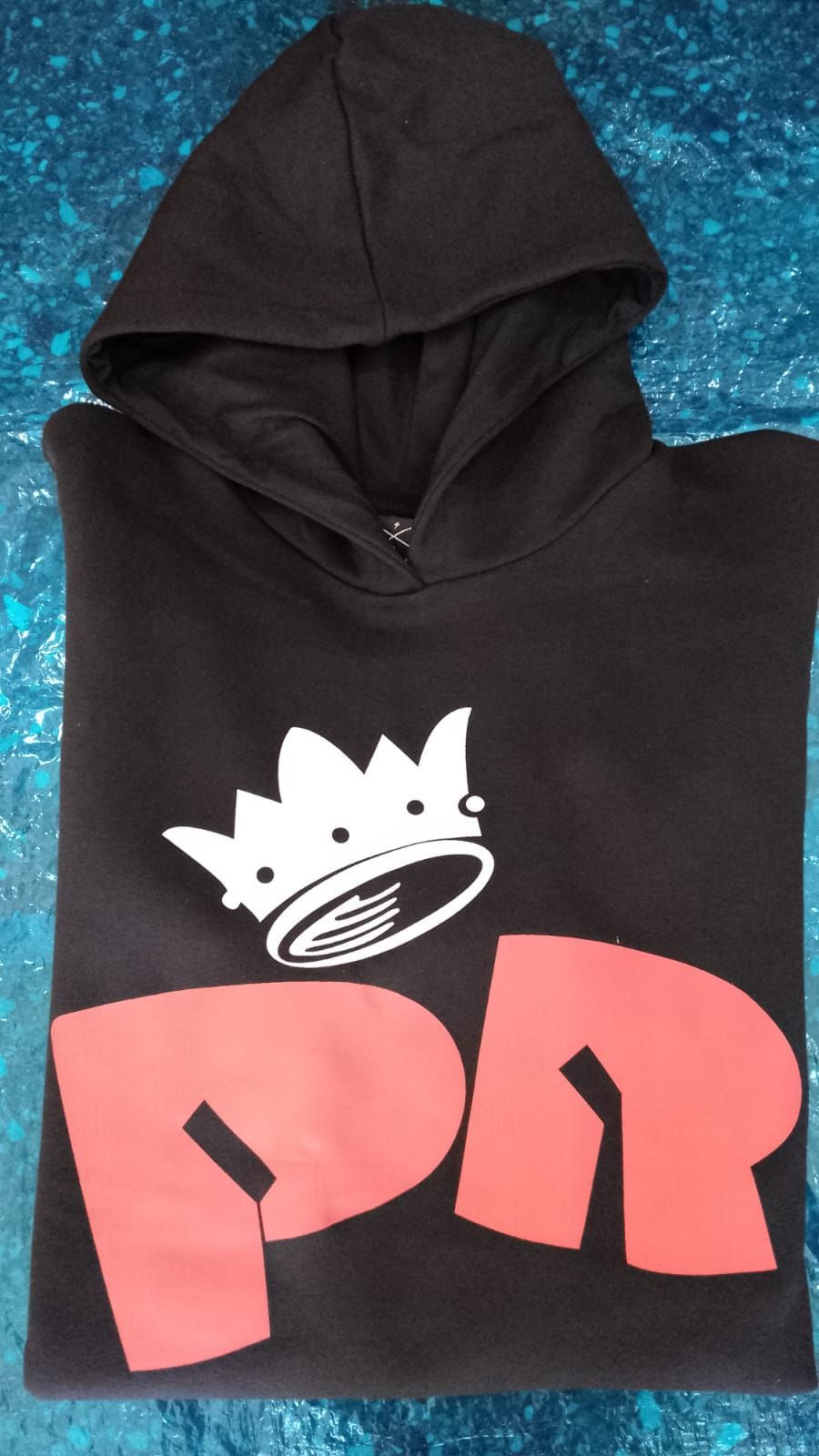Sudadera con capucha negra con el logo de una corona blanca y las letras grandes rosas 