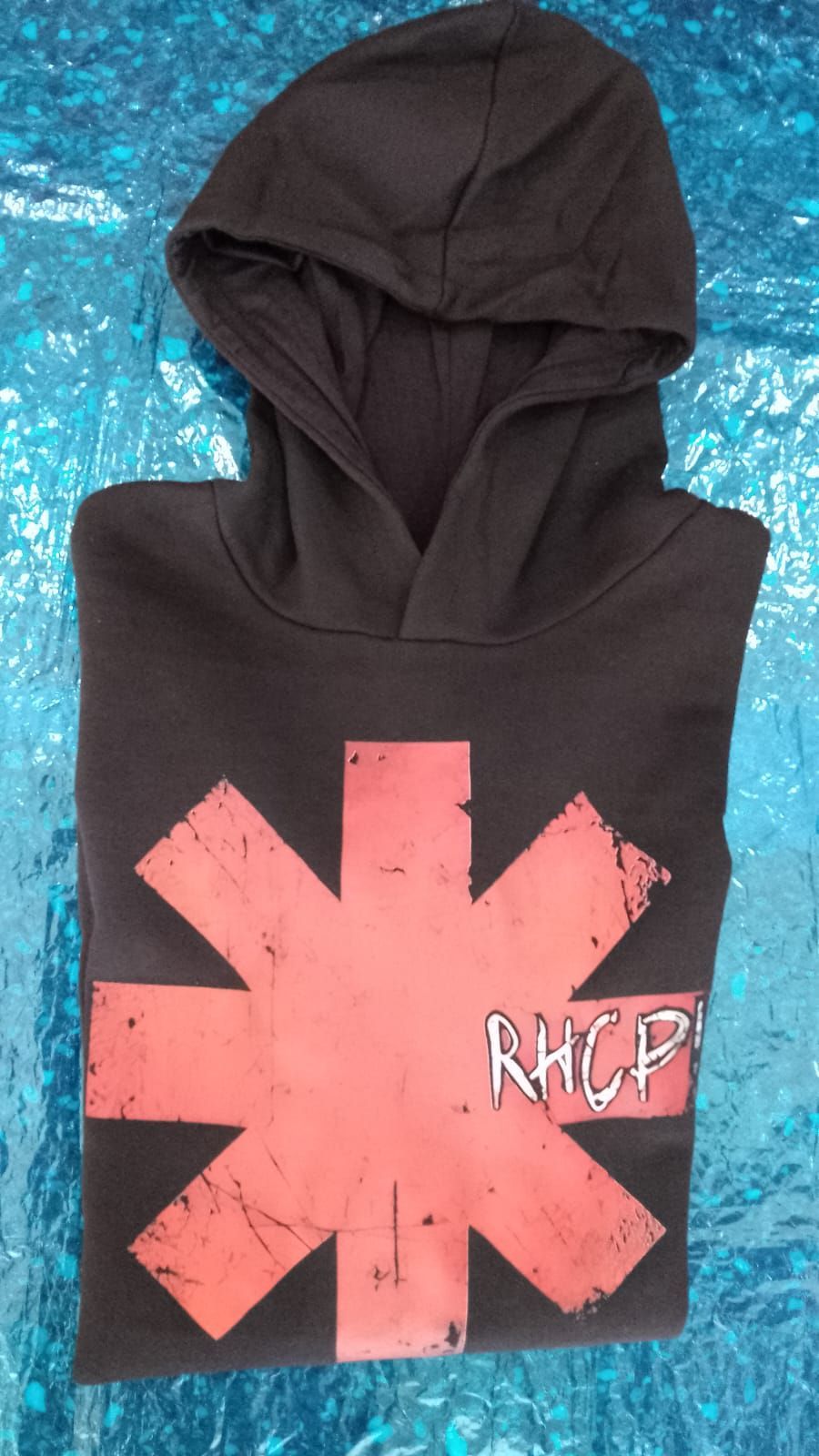 Sudadera negra con capucha, con un gran gráfico de una estrella color coral y el texto “RHCP” en letra pequeña en el pecho.