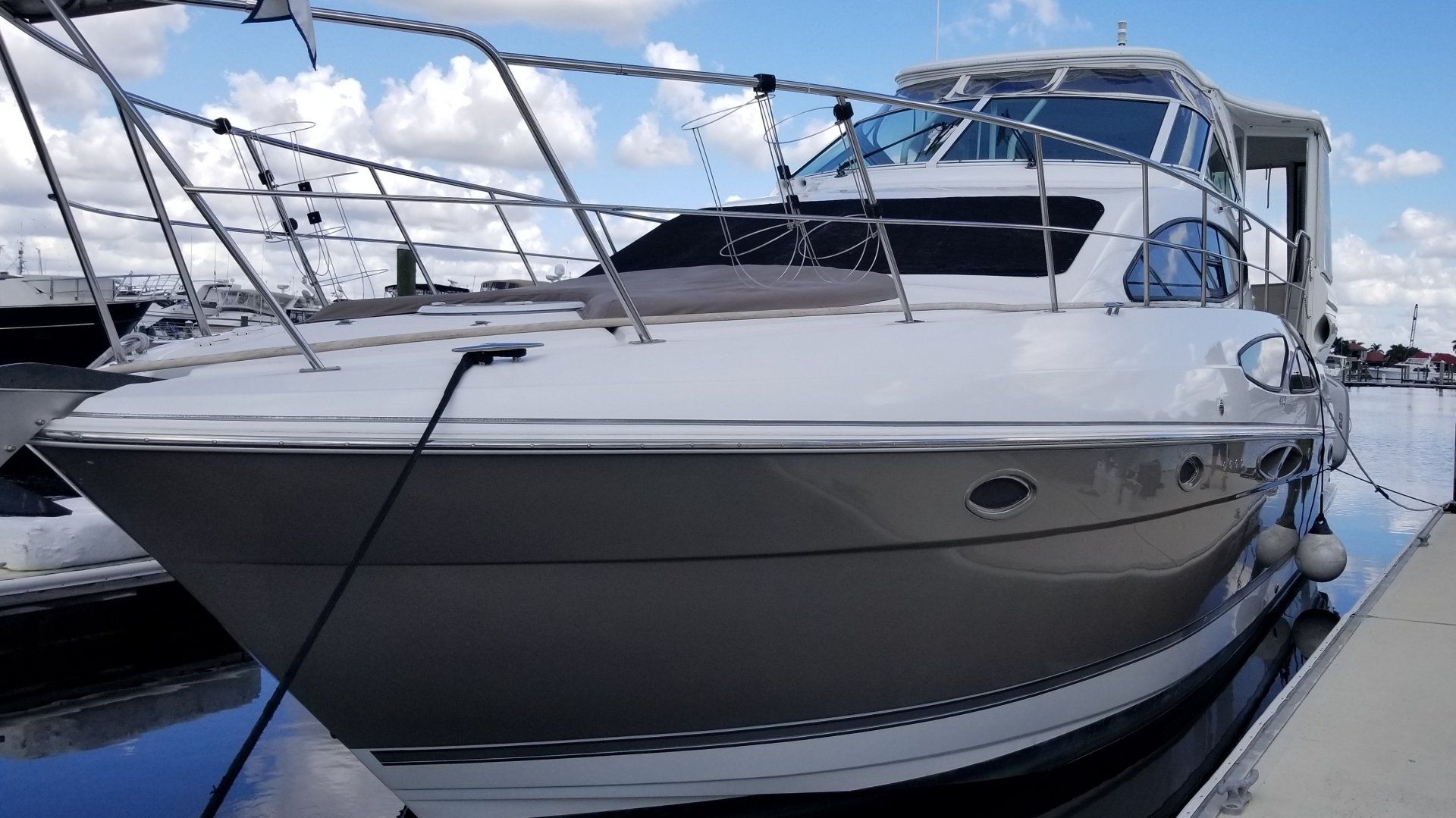 A boat is docked at a marina after a Diamond detail on a sunny day.