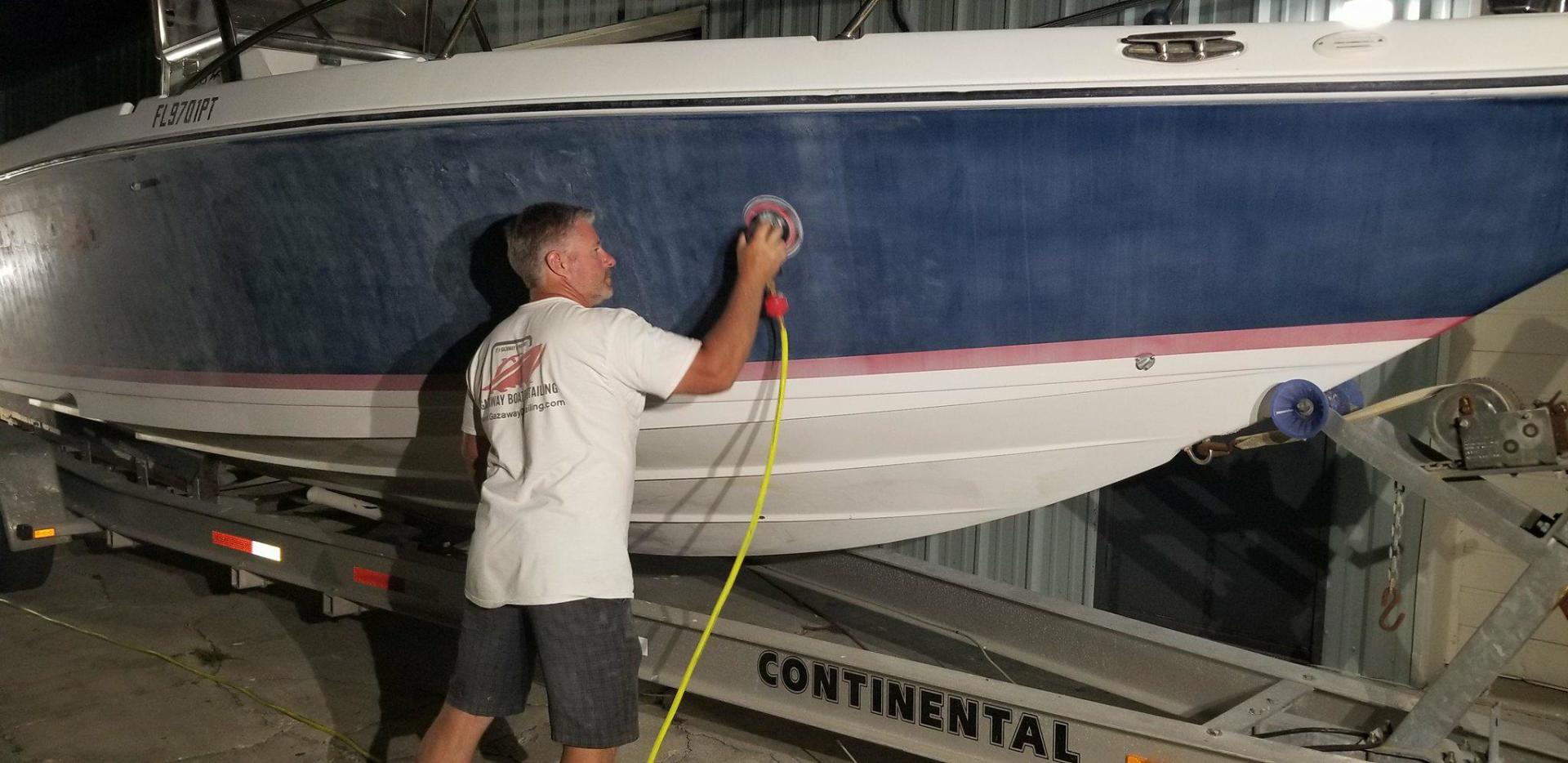 Sanding a boat on a trailer for color correction.