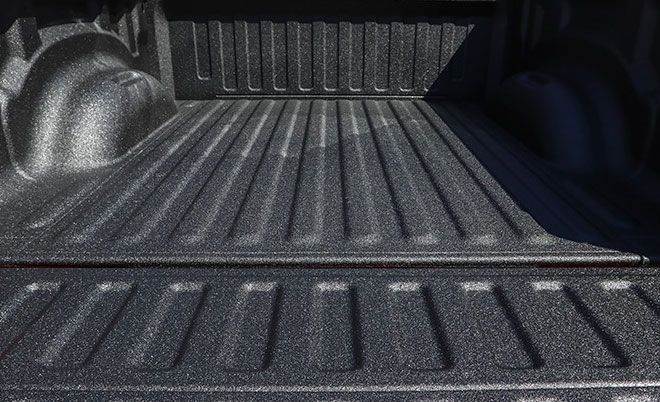 Textured black truck bed with ribbed floor.
