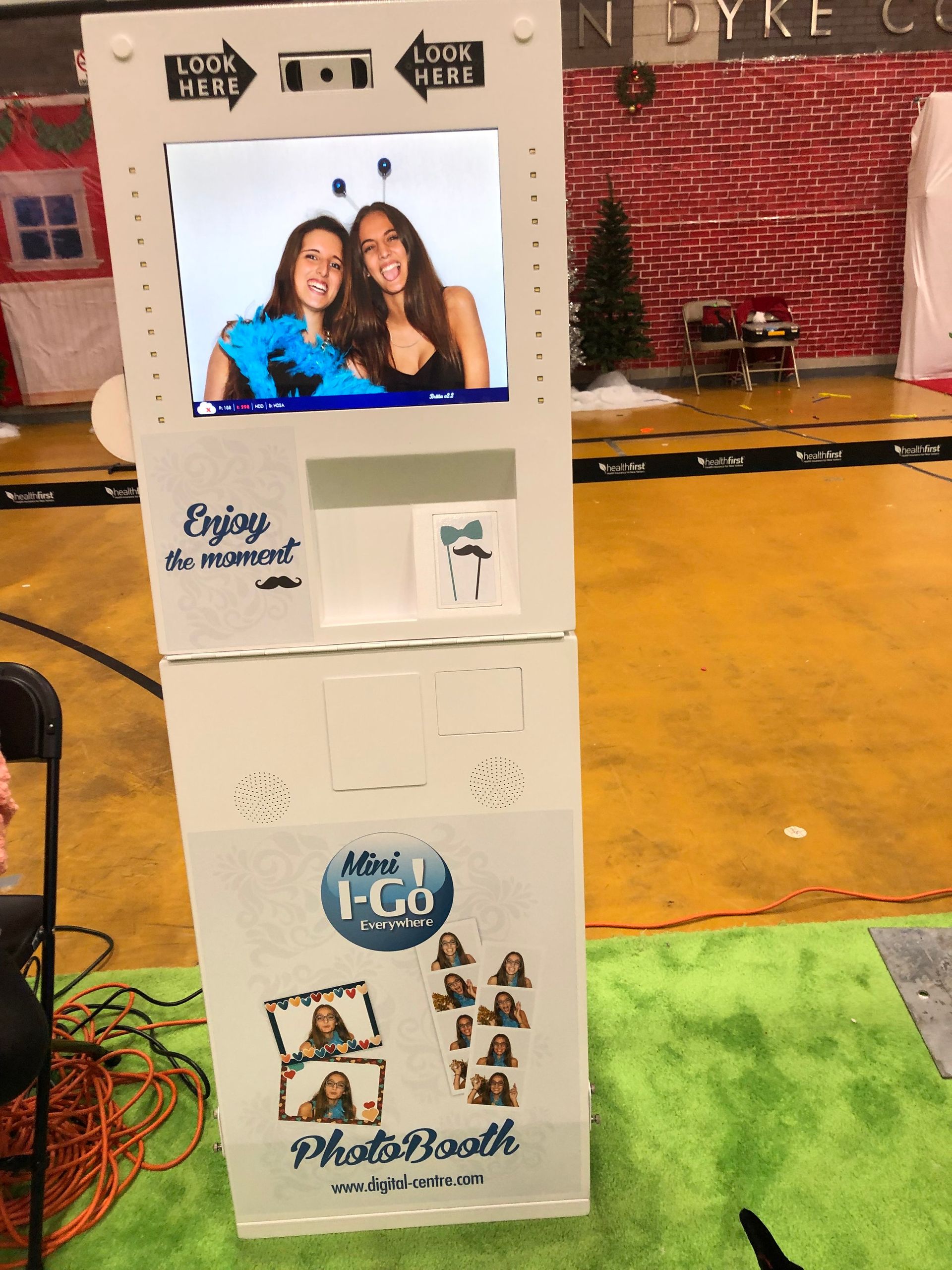 A white photo booth with two women on it