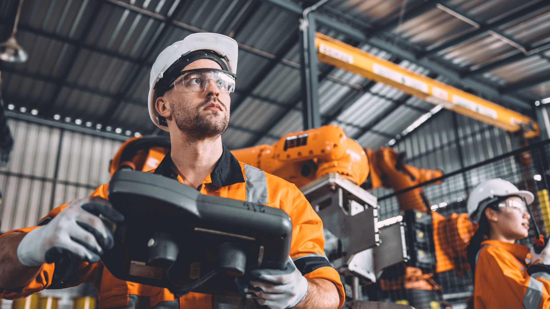 Engineer using a handheld device in an industrial setting, representing field service logistics and spare parts management in a service-led supply chain with SAP EWM.