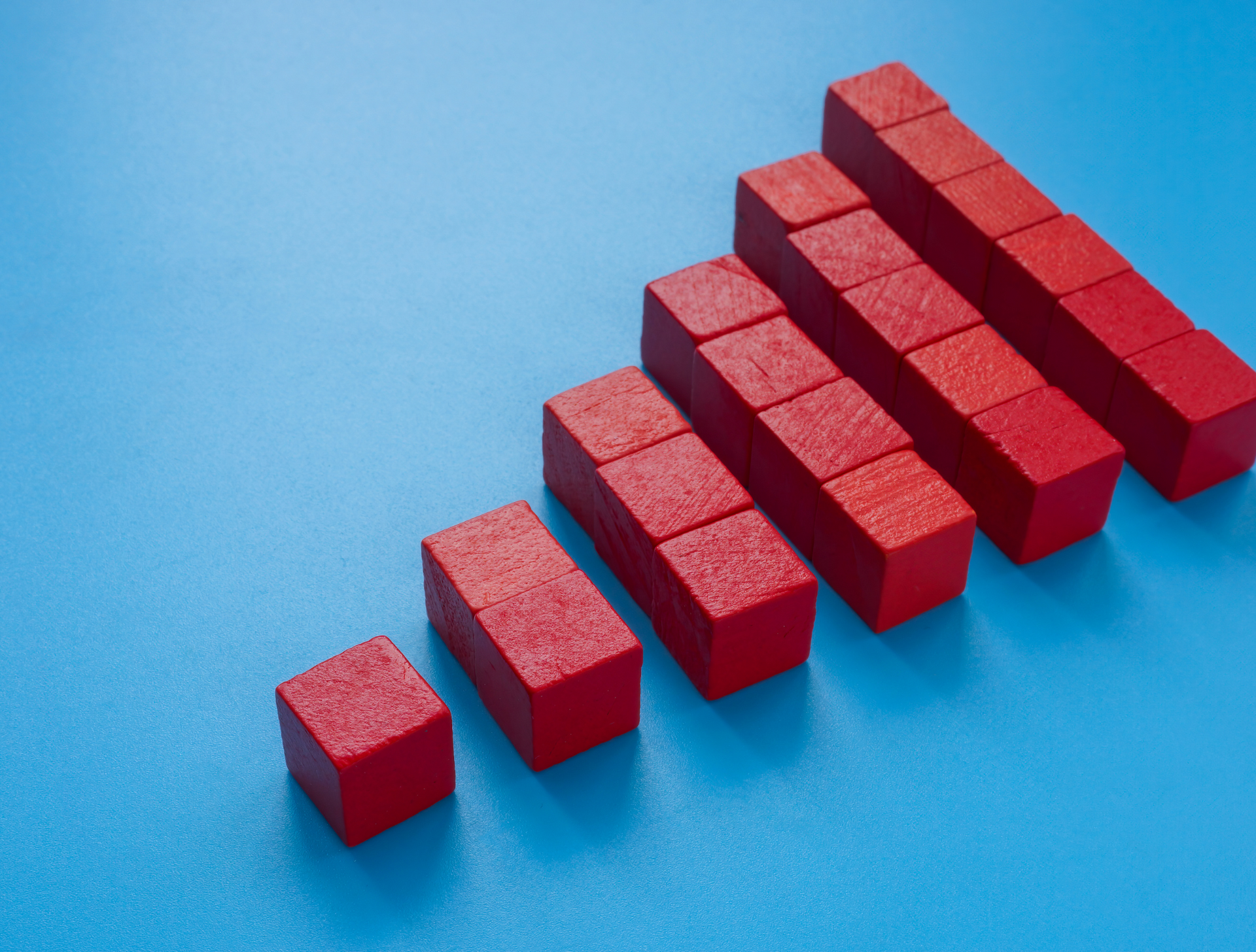 A row of red wooden blocks stacked on top of each other on a blue surface.
