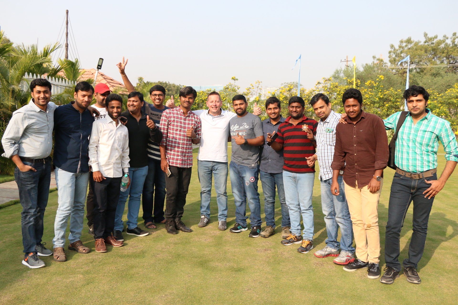 A group of young men are posing for a picture in a grassy field.