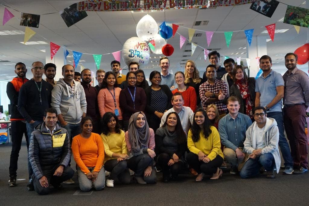 A large group of people are posing for a picture in an office.
