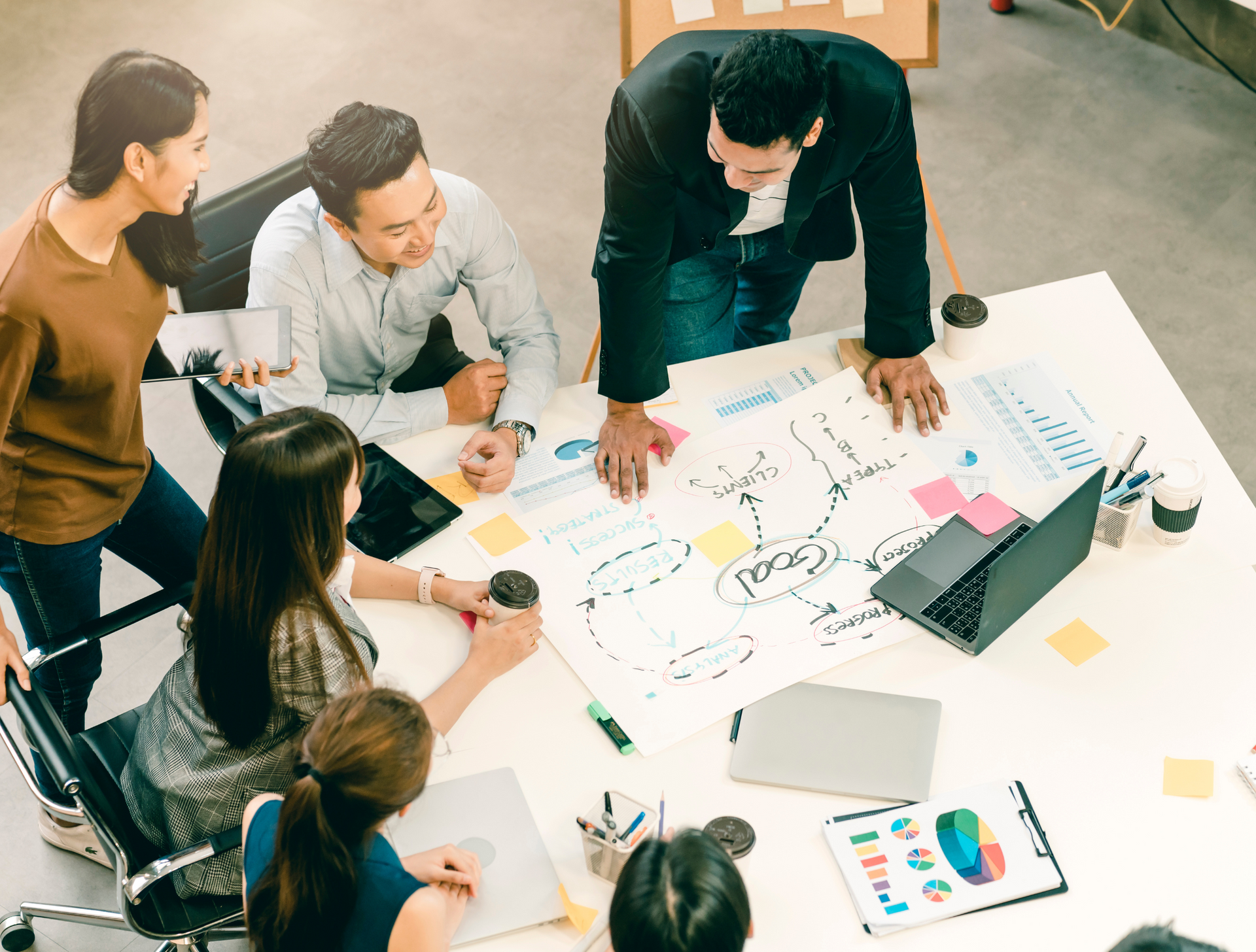 A group of people are sitting around a table having a meeting.