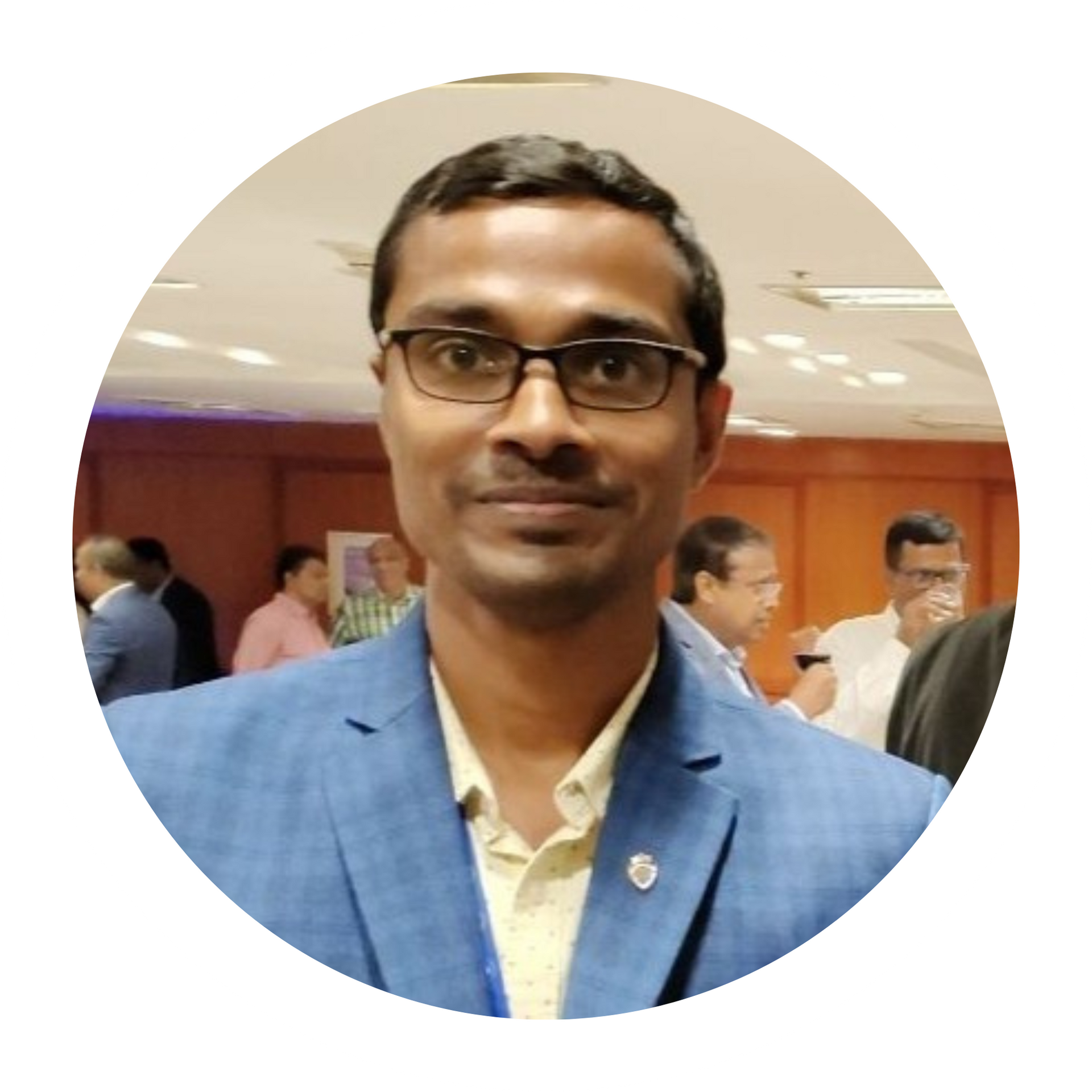 A man in a suit and blue shirt is smiling in a circle.