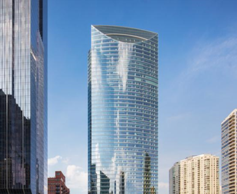 A tall building in the middle of a city with a blue sky in the background.