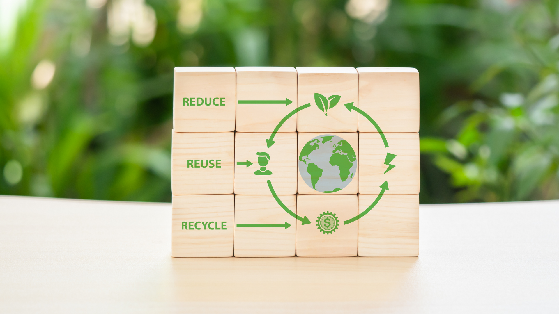 A wooden block with a picture of a recycling cycle on it.