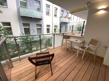 A balcony with a table and chairs on it