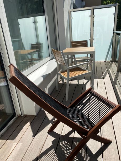 A wooden deck with a chair and a table