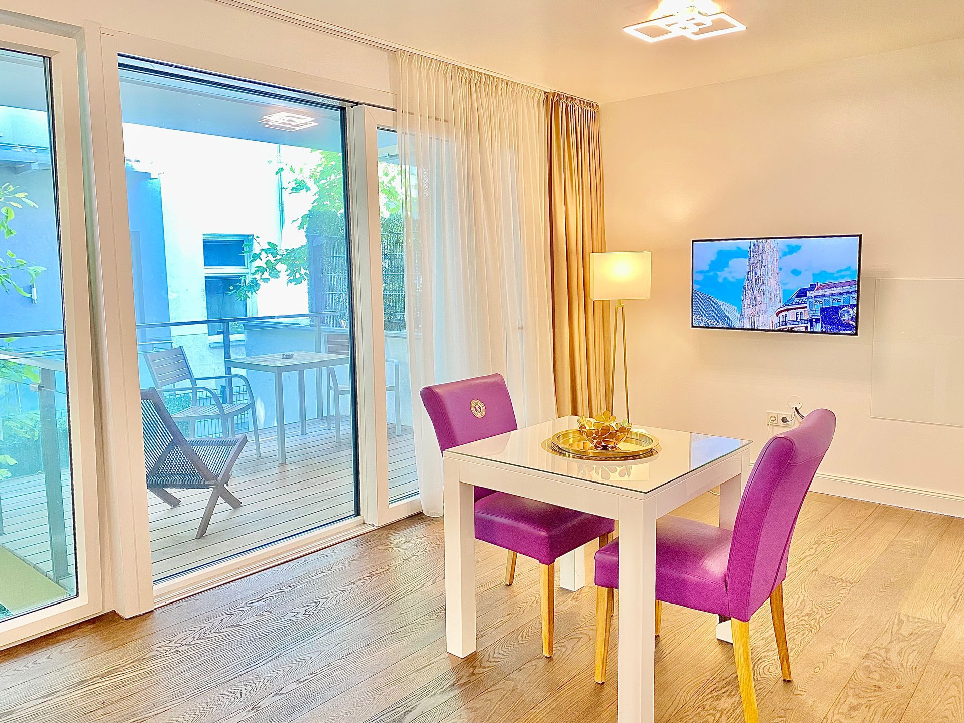 A living room with a table and chairs and a television.
