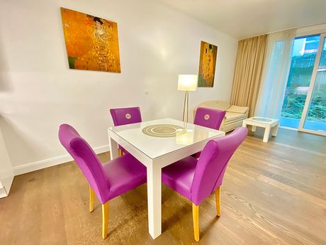 A living room with a dining table and purple chairs.