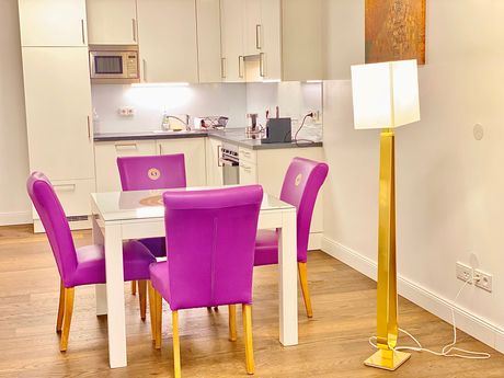 A kitchen with a table and chairs and a lamp