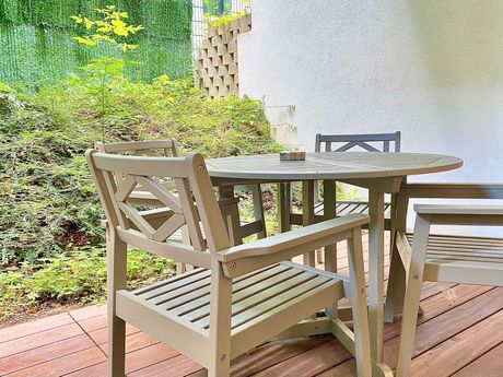 A table and chairs are sitting on a wooden deck.