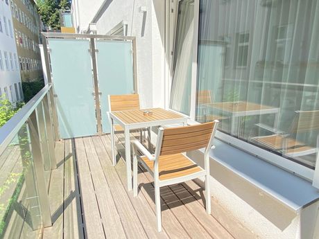 A balcony with a table and chairs on it