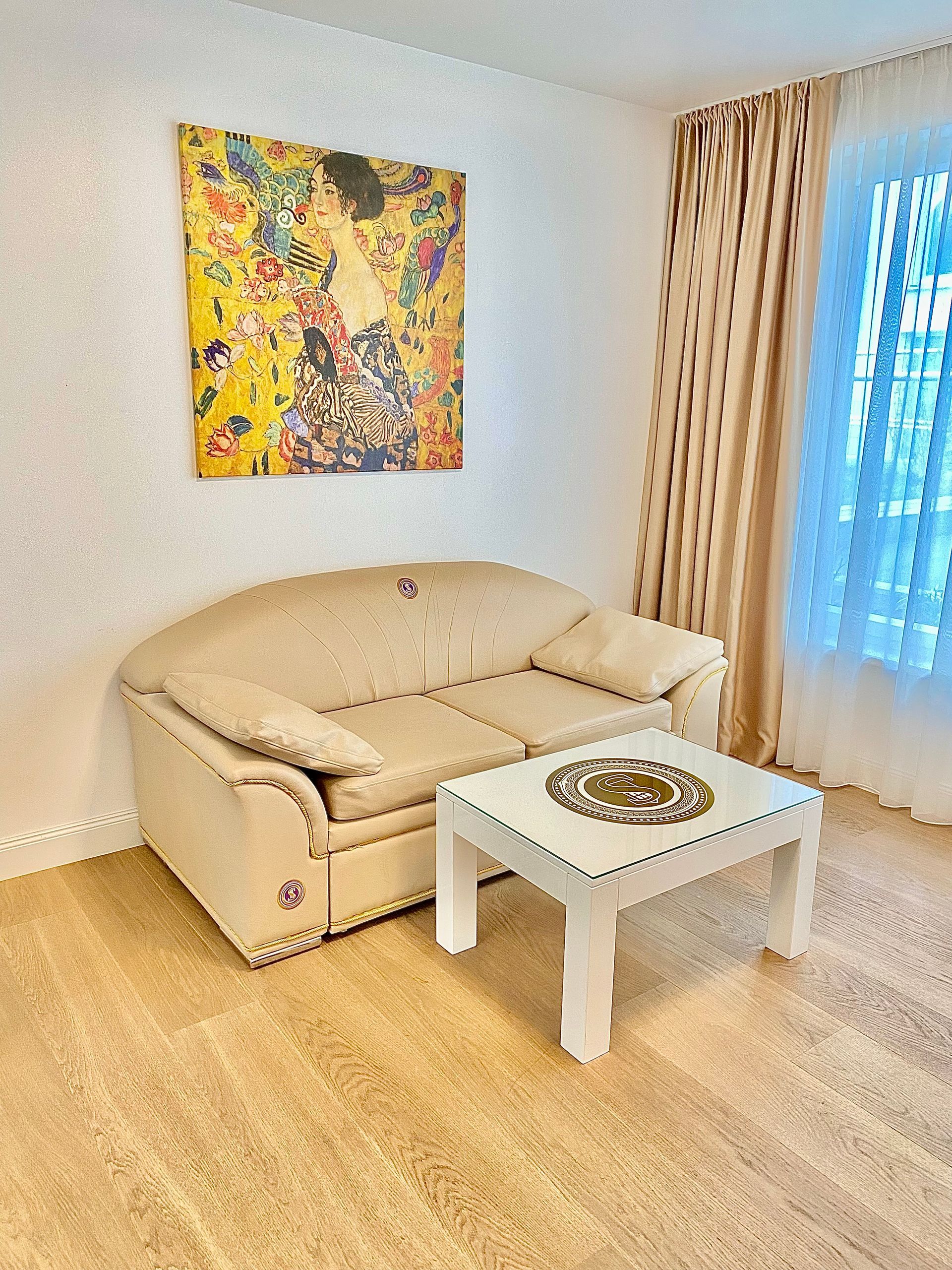 A living room with a couch , coffee table , and painting on the wall.