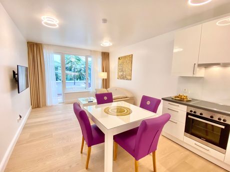 A living room with a dining table and purple chairs.