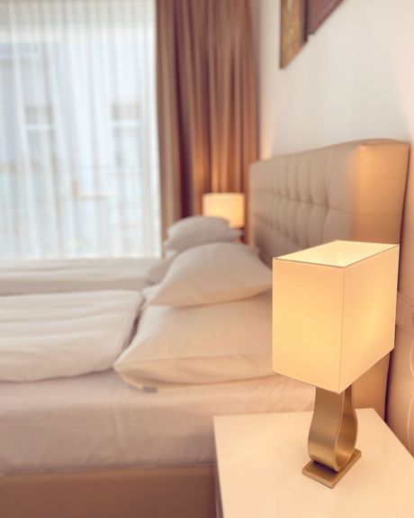 A bedroom with a bed and a lamp on a nightstand