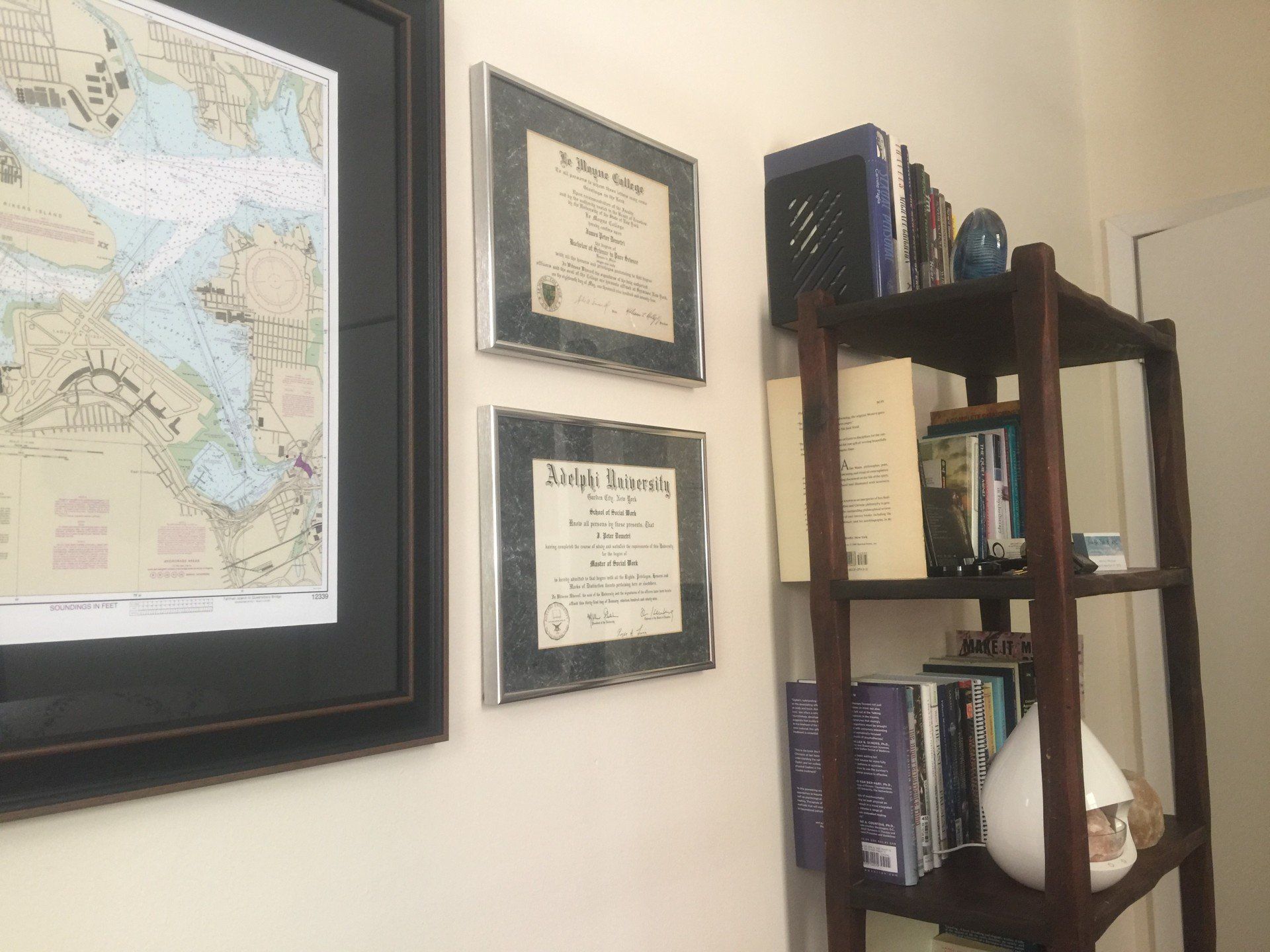 A room with a shelf and a map on the wall.