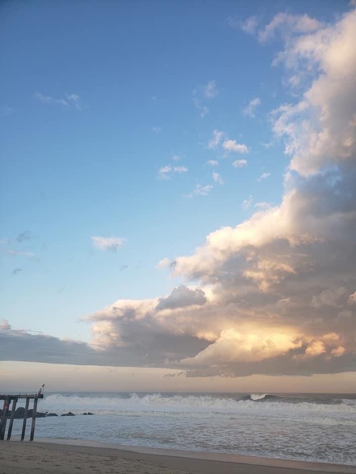 A sunset over the ocean with a pier in the foreground