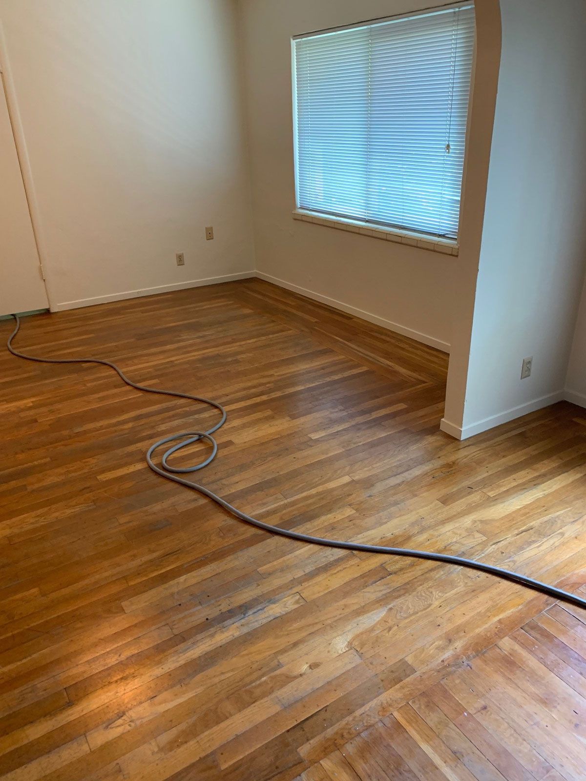 A living room with hardwood floors and a window.