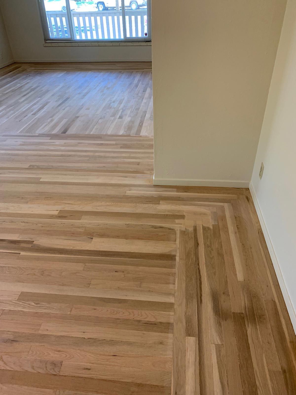 A living room with hardwood floors and a sliding glass door.