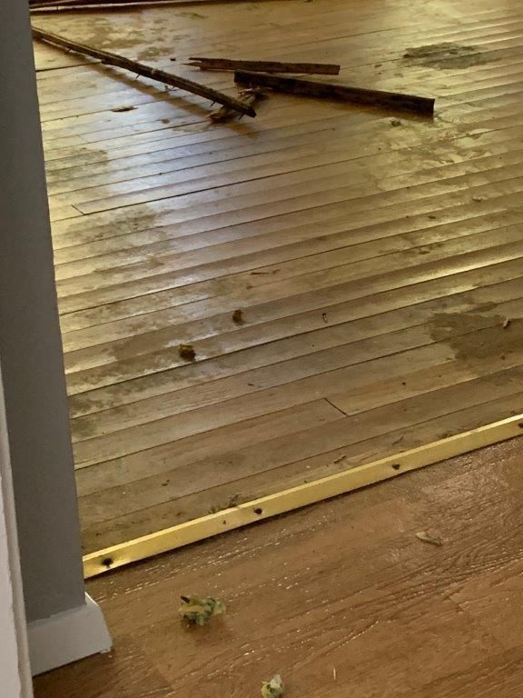 A wooden floor with a yellow trim in a room.