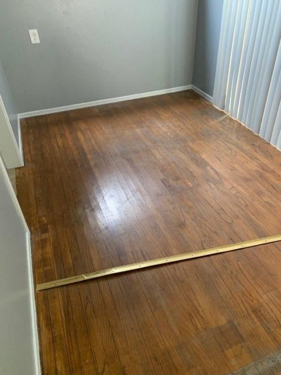 A room with hardwood floors and a brass trim.