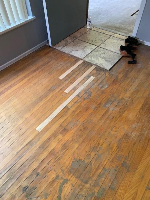 A wooden floor with a white line on it in a room.