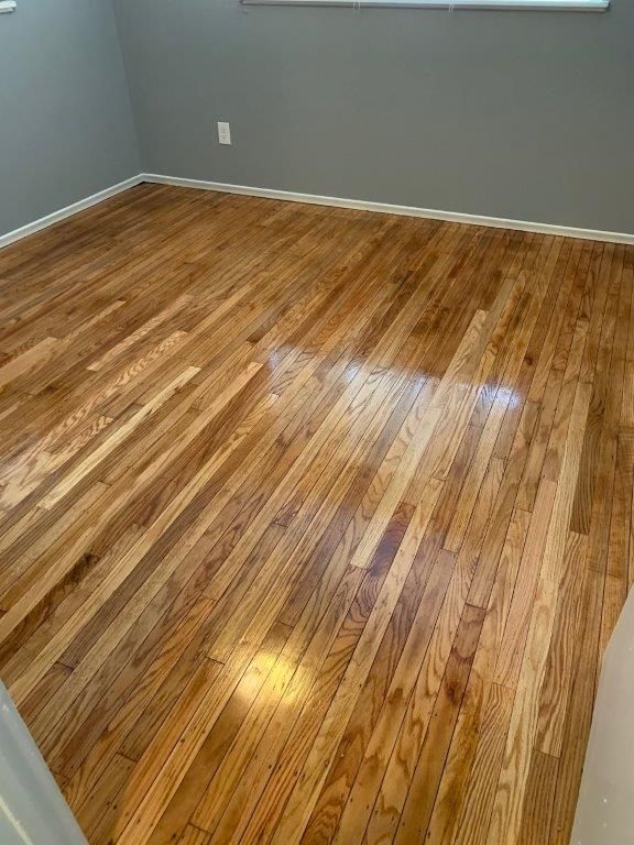 A bedroom with hardwood floors and gray walls.