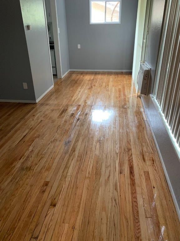 A living room with hardwood floors and a window.