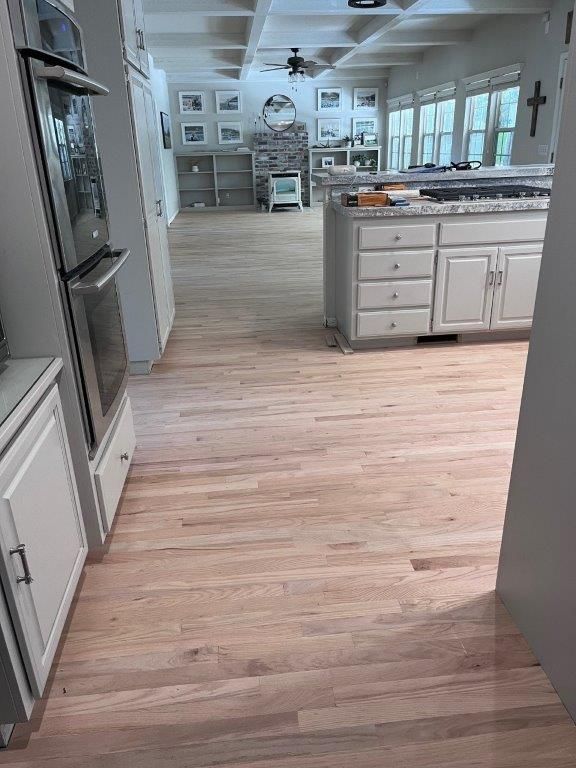 A kitchen with hardwood floors and white cabinets.