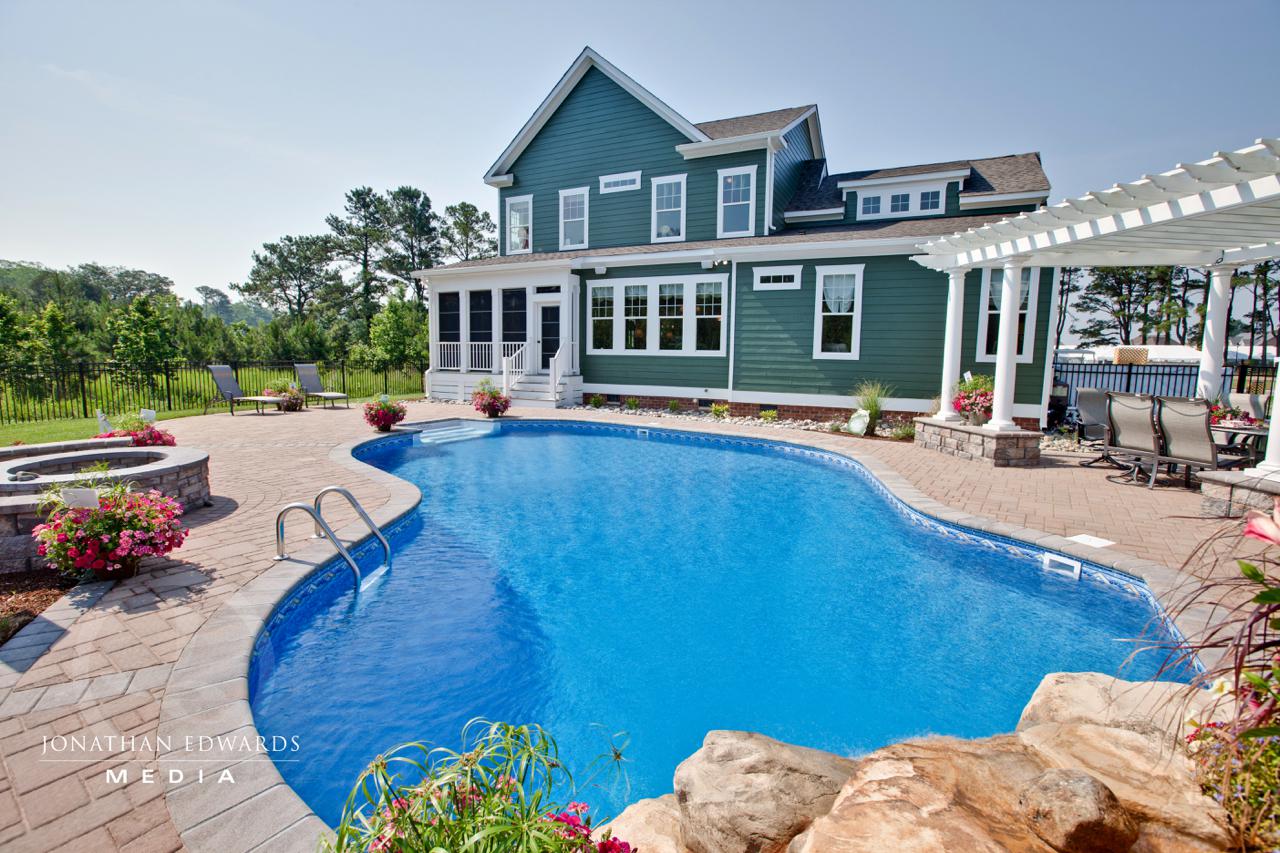 Backyard with pool and exterior of elegant green home | Exterior Gallery | Stephen Alexander Homes | Chesapeake, VA