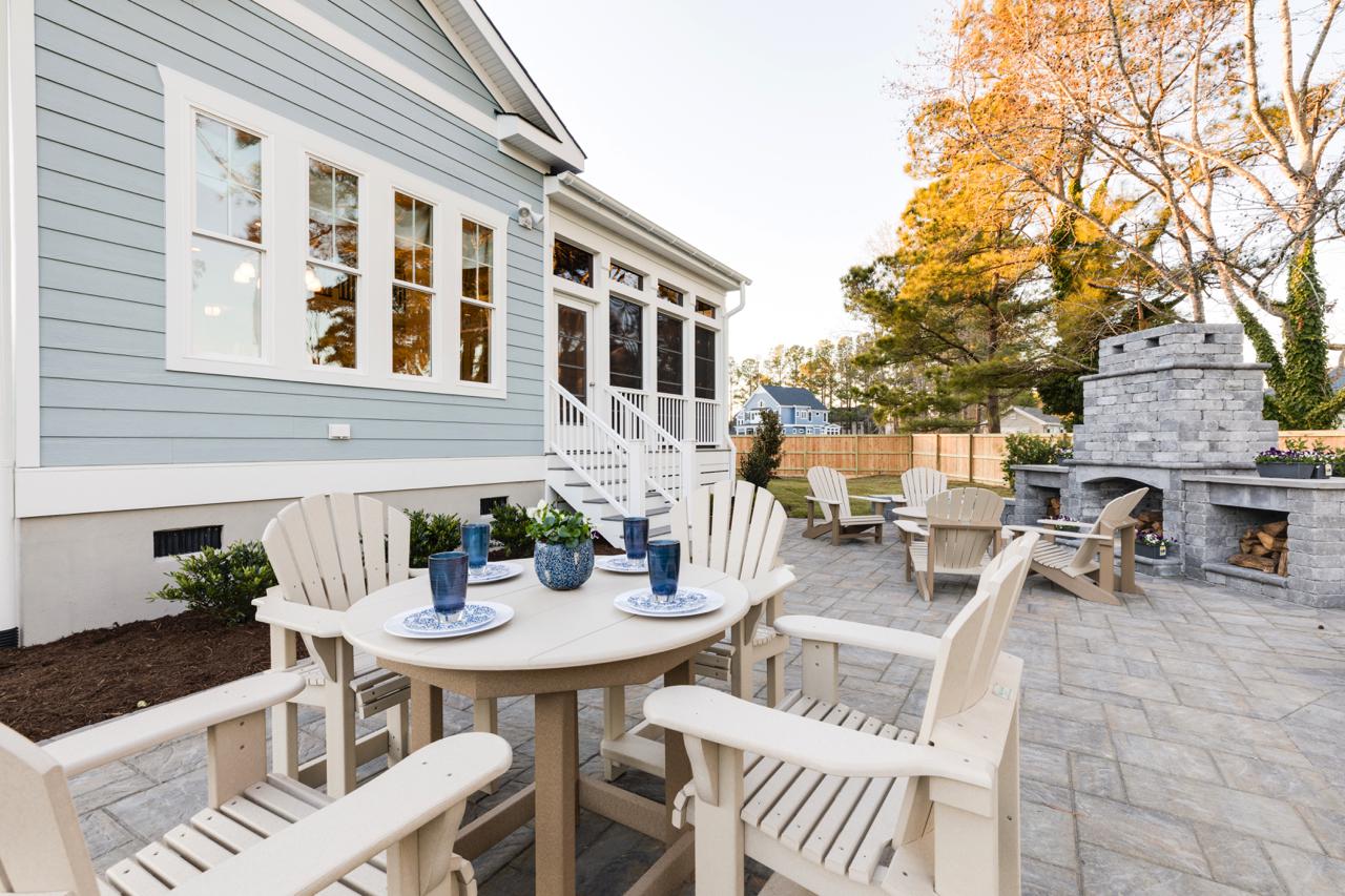 Elegant rear exterior of teal home with seating and outdoor fireplace  | Exterior Gallery | Stephen Alexander Homes | Chesapeake, VA