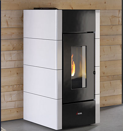 Stufa a pellet bianca e nera con fiamme a vista, appoggiata a una parete rivestita in legno.