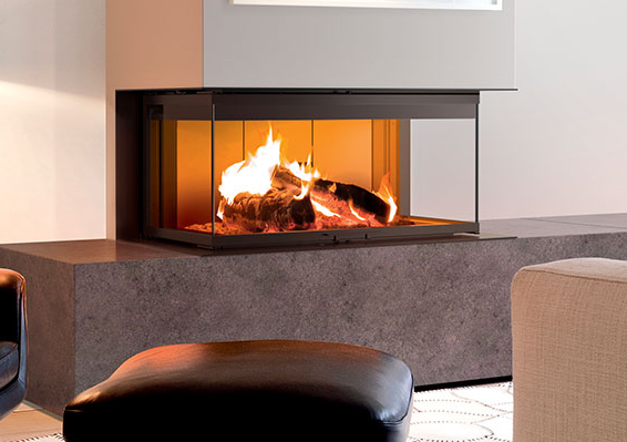 Caminetto moderno con ceppi ardenti incastonati in una base in pietra grigia, frontale in vetro, contro una parete bianca.