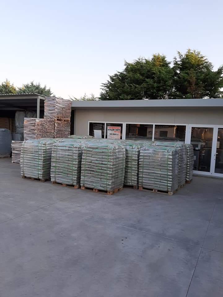 Un edificio con un sacco di pallet davanti.