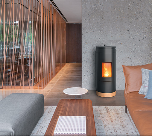 Soggiorno con stufa moderna, divano marrone, tavolino da caffè in legno e divisorio decorativo in rame.