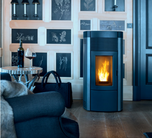 Una moderna stufa a pellet con fuoco acceso, accanto a un tavolino con del vino e una borsa.