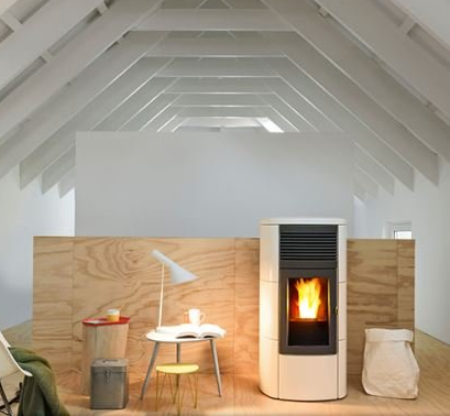 Una stufa a pellet bianca con fiamme in un loft moderno con pannelli in legno e soffitto spiovente.