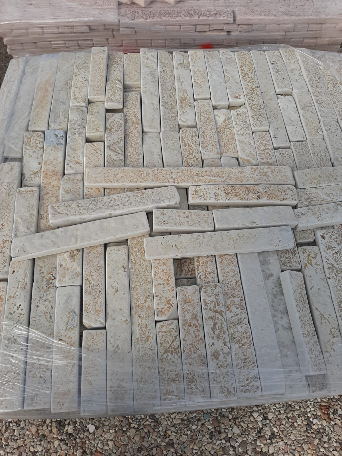 Pila di piastrelle rettangolari di pietra chiara, possibilmente di granito, all'esterno.