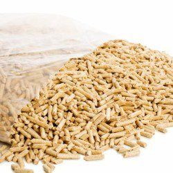 Mucchio di pellet di legno che fuoriesce da un sacchetto di plastica trasparente; colore marrone chiaro.