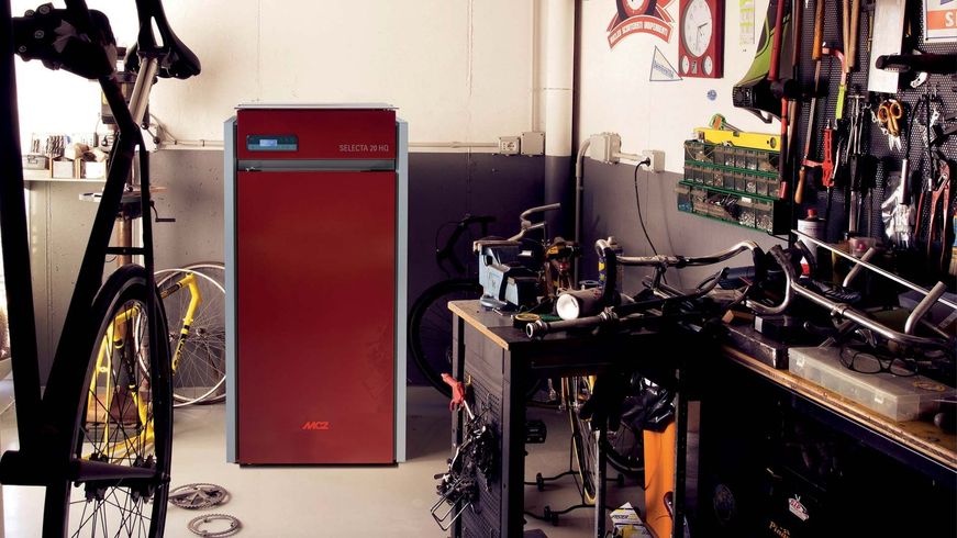 Elettrodomestico rosso in un'officina con biciclette, attrezzi e scaffali ingombri.