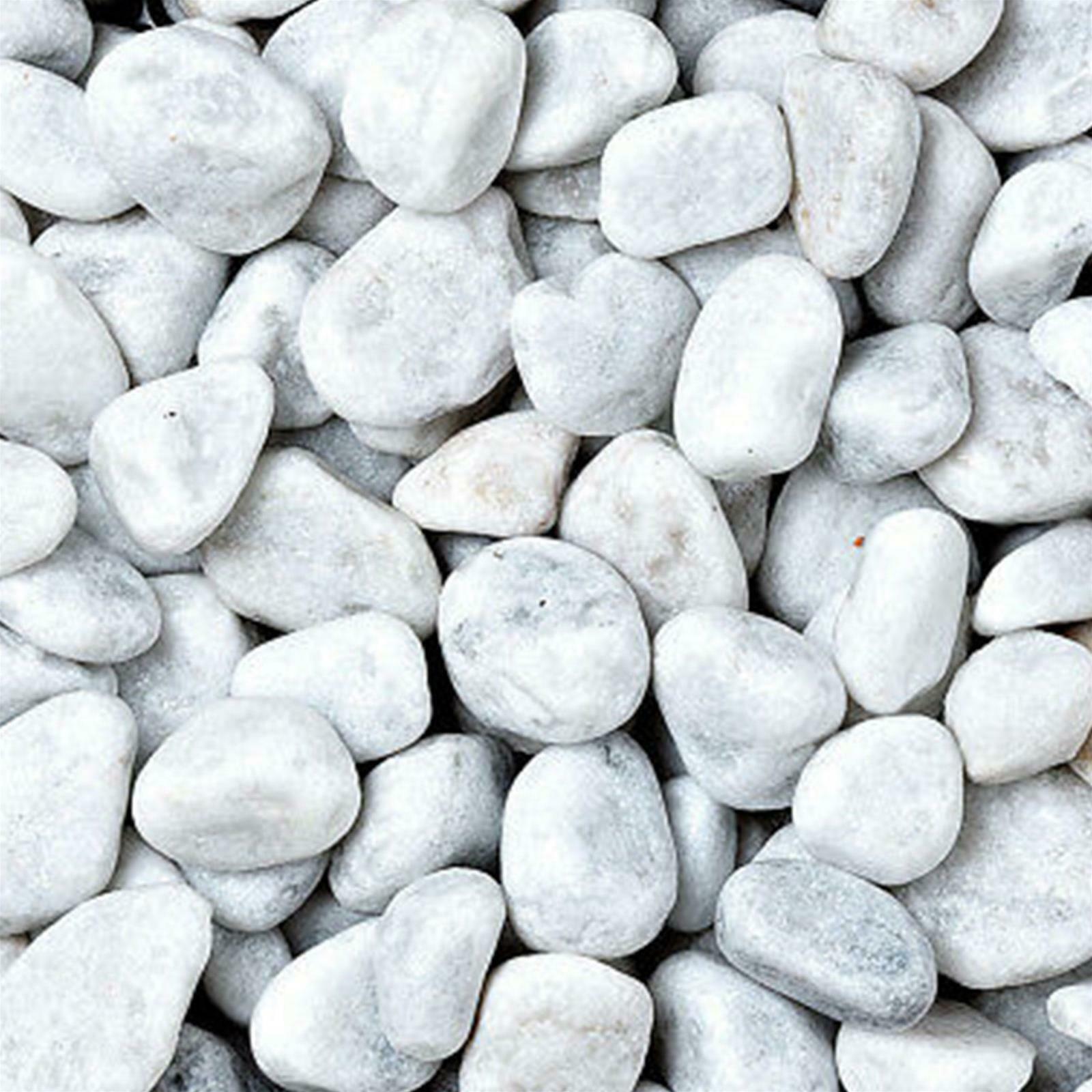 Pietre di fiume bianche e lisce ammucchiate insieme; alcune sono grigie.